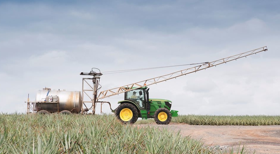 A tractor transports the harvester to the pineapple field during the harvest at Pinata Farms