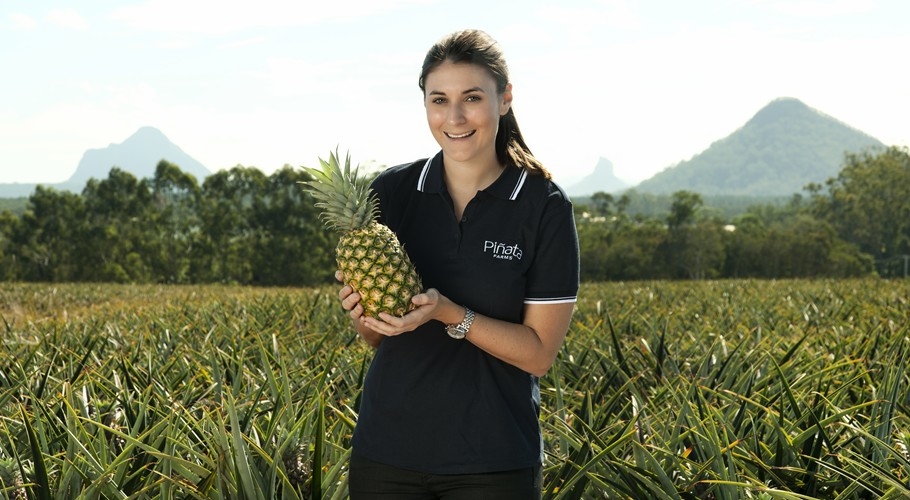 Key account manager Rebecca Scurr holds a pinepaple in the field at Pinata Farms, Wamuran